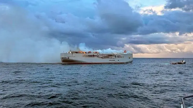A freighter carrying nearly 3,000 cars catches fire in the North Sea and a crew member is killed
