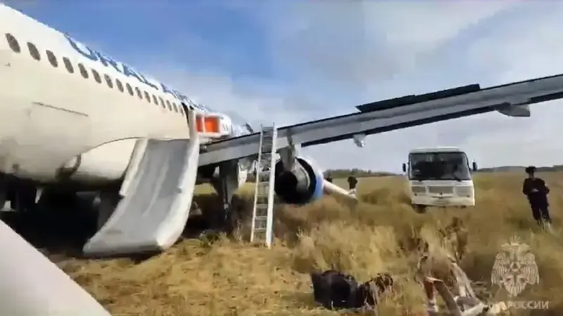 A Russian passenger jet with a hydraulics problem makes a safe emergency landing in an open field
